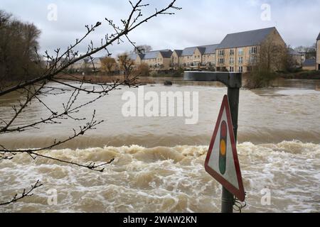 St Neots, Royaume-Uni. 06 janvier 2024. Un panneau d'avertissement des feux de circulation devant vous est entouré par une cascade d'eau de crue qui couvre la route alors que la rivière Great Ouse brise ses rives. Les alertes aux inondations restent en place alors que les eaux continuent de monter dans l'est de l'Angleterre à la suite de la tempête Henk. Les rivières principales la rivière Great Ouse et la rivière Nene ont éclaté leurs rives et se sont déversées sur la campagne environnante et avec des drains pleins à pleine capacité, ils soutiennent dans les zones résidentielles. Crédit : SOPA Images Limited/Alamy Live News Banque D'Images