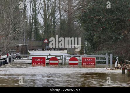 St Neots, Royaume-Uni. 06 janvier 2024. Des panneaux de signalisation indiquant «route fermée» et aucun panneau d'entrée ne sont attachés aux portes qui empêchent la circulation en utilisant la route inondée lorsque la rivière Great Ouse éclate ses rives. Les alertes aux inondations restent en place alors que les eaux continuent de monter dans l'est de l'Angleterre à la suite de la tempête Henk. Les rivières principales la rivière Great Ouse et la rivière Nene ont éclaté leurs rives et se sont déversées sur la campagne environnante et avec des drains pleins à pleine capacité, ils soutiennent dans les zones résidentielles. Crédit : SOPA Images Limited/Alamy Live News Banque D'Images