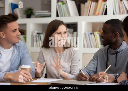 Étudiants multiraciaux motivés discutant du projet scolaire en classe Banque D'Images