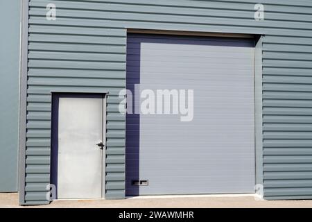 volets roulants de façade d'entrée sur la porte de sortie de secours de bâtiment gris dans l'unité industrielle commerciale Banque D'Images