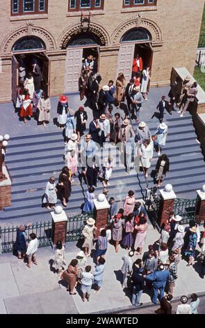 Les hommes et les femmes juifs orthodoxes modernes quittent leur synagogue à la fin des offices du samedi matin. Sur la 14e Avenue à Borough Park, Brooklyn, New York vers 1976. Banque D'Images