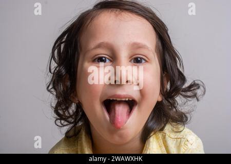 Closeup portrait of boy alittle coller sa langue out Banque D'Images