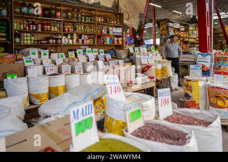 Homme traditionnel vendant des épices, de la farine et de la nourriture, étal de marché à Osh Bazaar, Bichkek, Kirghizistan Banque D'Images