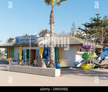 Boutique de surf colorée avec planches de surf et kayaks sur la promenade dans la ville d'Essaouira, Maroc. 7 janvier 2024 Banque D'Images