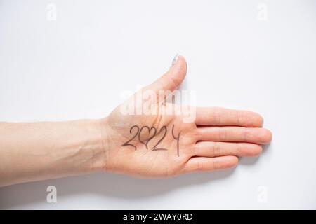 2024 et un coeur à la place de zéro est écrit sur la main d'une femme qui repose sur un fond blanc, aide et soutien dans la nouvelle année 2024, amour Banque D'Images