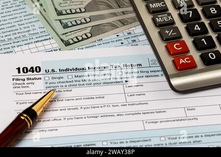 1040 formulaires de déclaration de revenus des particuliers fédéraux, argent comptant et calculatrice. Déclaration d'impôt fédérale, impôt sur le revenu et concept de remboursement d'impôt. Banque D'Images