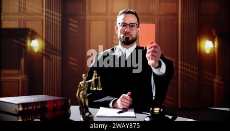 Juge dans la salle d'audience montrant carton rouge. Règles et droit du procès Banque D'Images