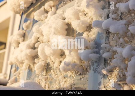 Vue rapprochée du mur de la villa couverte de neige après la chute de neige sur la journée d'hiver gelée et ensoleillée. Suède. Banque D'Images