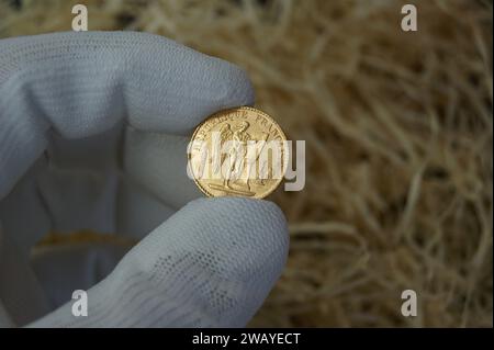 Une vieille pièce d'or française dans la main d'un numismatiste. 20 francs 1885. Banque D'Images