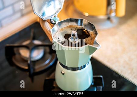 Machine à café geyser avec boisson de café sur la cuisinière de la cuisine à la maison le matin. Photo de haute qualité Banque D'Images
