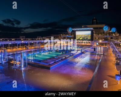 Vue nocturne de la terrasse principale de la piscine (The Atmosphere Pool) sur le MSC Euribia naviguant en Europe du Nord (23 juillet). Banque D'Images