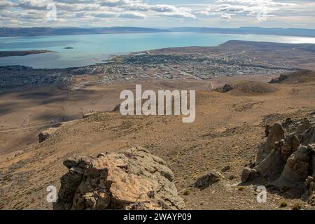 Vue aérienne d'un paysage urbain animé avec une montagne imposante au premier plan, entourée par d'autres sommets en arrière-plan Banque D'Images