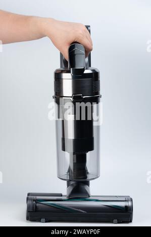 Gros plan de l'aspirateur gris à la main isolé sur fond de studio blanc Banque D'Images