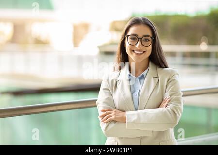 Jeune femme d'affaires confiante avec un sourire lumineux portant des lunettes Banque D'Images