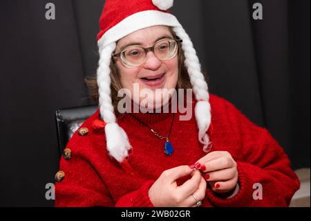 Femme de 41 ans avec le syndrome de Down, habillée en Père Noël à la maison, Bruxelles, Belgique Banque D'Images