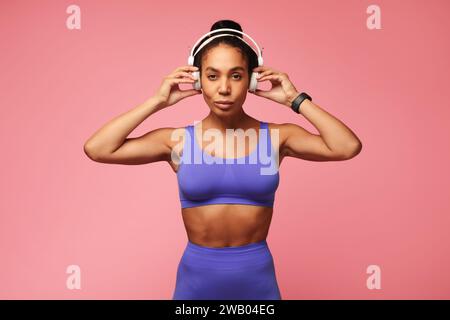 Athletic African American sportswoman en tenue de gym portant des écouteurs, studio Banque D'Images