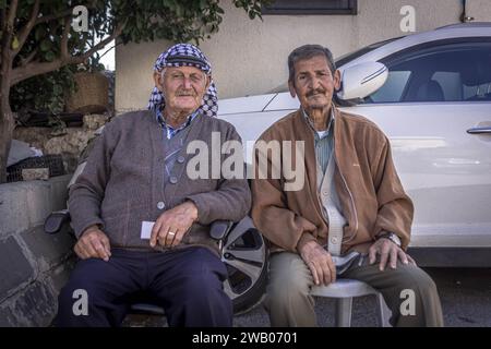 Deux Arabes palestiniens, dont un avec la kuffiyah traditionnelle, assis dans la rue de Bethléem, Cisjordanie (Palestine). Banque D'Images