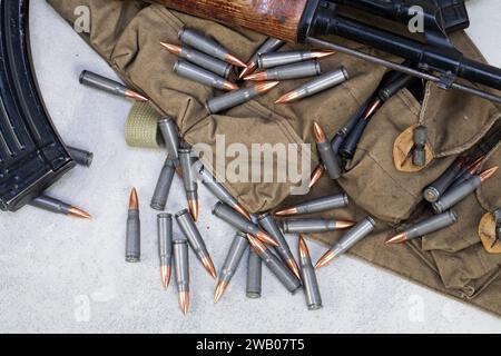 Pistolet Kalashnikov ak et Chicom Chest Rig avec cartouches de 7,62 mm sur fond de béton gris Banque D'Images