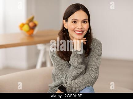 Portrait de jeune femme brune joyeuse posant à la maison Banque D'Images