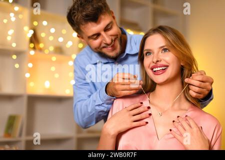 Homme cadeau collier à la femme ravie dans un cadre festif Banque D'Images