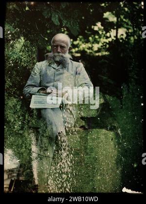 Double tirage d'un portrait d'un homme, peut-être adolphe burdet, et d'un chien, couché dans l'herbe, v. 1907 - v. 1930 photographie. diapositive couleur. Photo composite Double pression d'un vieil homme avec une barbe assis sur une chaise sur une pelouse. Il a un journal de la semaine littéraire sur ses genoux. Et une absorption d'un chien couché dans l'herbe. Chien coulissant en verre néerlandais Banque D'Images