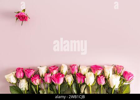 Beau fond de fête avec espace de copie avec des roses blanches et roses. La bordure est plus basse. cadre. Fond rose. Vue de dessus Banque D'Images