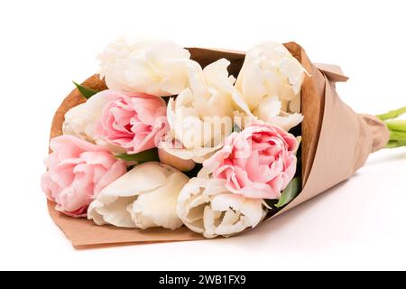 Bouquet de doubles tulipes blanches et roses enveloppées dans du papier brun recyclé isolé sur fond blanc. Bouquet de tulipes. Banque D'Images