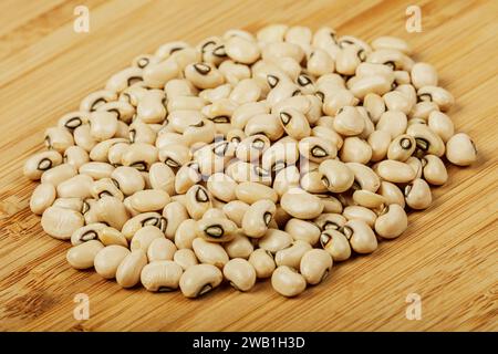 Gros plan d'un tas de Black Eyed Peas également connu sous le nom de Black Eyed Beans sur un fond en bois avec espace de copie Banque D'Images