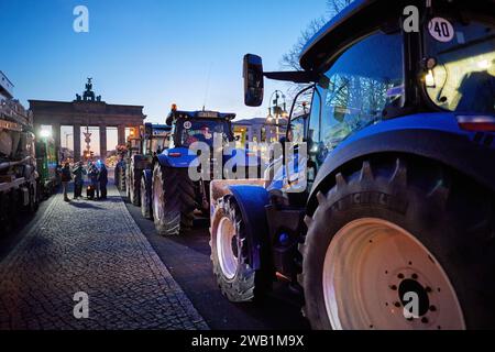 Berlin, Allemagne. 08 janvier 2024. De nombreux tracteurs se dressent devant la porte de Brandebourg lors d'une manifestation paysanne sur la Straße des 17. En réponse aux plans d'austérité du gouvernement fédéral, l'association des agriculteurs a appelé à une semaine d'action avec des rassemblements et des rassemblements à partir du 8 janvier. Il devrait culminer par une manifestation majeure dans la capitale le 15 janvier. Crédit : Jörg Carstensen/dpa/Alamy Live News Banque D'Images