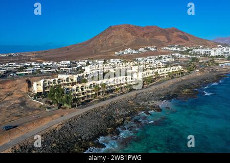 Côte de Playa Blanca. Vue panoramique drone aérien avec volcan rouge en arrière-plan. Tourisme et concept de vacances. Flamingo Beach Lanzarote, Canar Banque D'Images