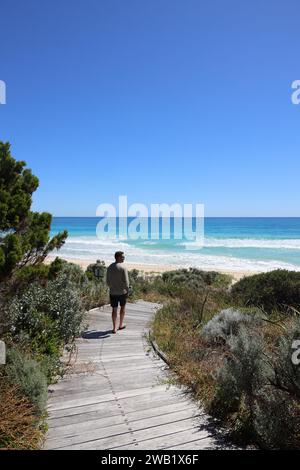 Un homme en silhouette debout sur un chemin, regardant l'immensité de l'océan Banque D'Images