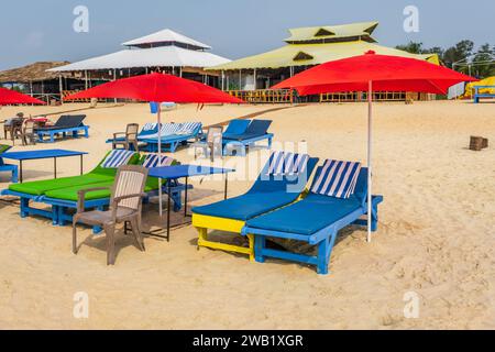 parasols de plage en bois coloré et chaises longues sur la plage de sable de l'océan Banque D'Images