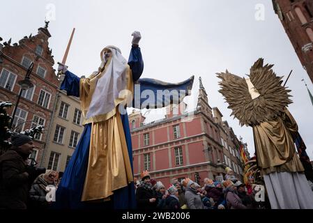 Les figures des anges et de la foule rassemblée lors de la Fête des trois Rois le 6 janvier est célébrée dans l'Église catholique comme la Fête de l'Epiphanie, connue sous le nom d'Epiphanie. À GDA?sk, chaque année à midi, devant la basilique Sainte-Marie, la foule rassemblée des participants à la procession de l'Épiphanie récite ensemble la prière de l'Angélus et part dans un défilé coloré. Des milliers de résidents de GDA?sk et de visiteurs de chez eux et à l'étranger ont pris part à la procession de l'Epiphanie de cette année. À la fin, les participants ont chanté de magnifiques chants polonais. Banque D'Images