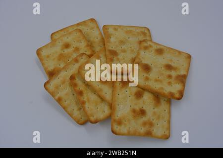 Biscuits de marque, fabriqués en usine, de grands crackers salés minces sont disposés sur un fond blanc. Banque D'Images