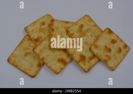 Biscuits de marque, fabriqués en usine, de grands crackers salés minces sont disposés sur un fond blanc. Banque D'Images