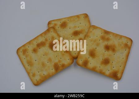 Biscuits de marque, fabriqués en usine, de grands crackers salés minces sont disposés sur un fond blanc. Banque D'Images