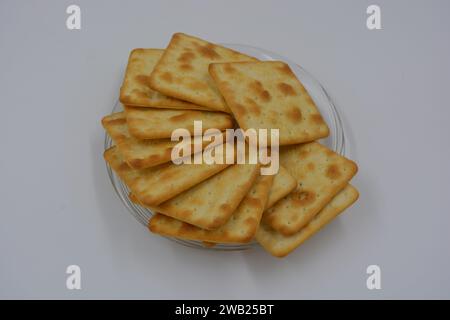 Biscuits de marque, fabriqués en usine, de grands crackers salés minces sont disposés sur un fond blanc. Banque D'Images