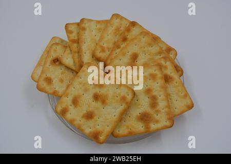 Biscuits de marque, fabriqués en usine, de grands crackers salés minces sont disposés sur un fond blanc. Banque D'Images