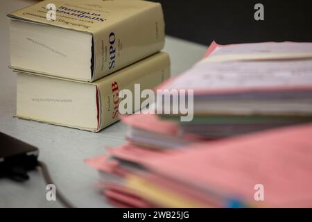 Essen, Allemagne. 08 janvier 2024. Les dossiers du procès sont sur la table du juge avant le début de l'audience aux côtés du StPO (Code de procédure pénale) et du StGB (Code pénal). Une femme de 31 ans d'Essen doit répondre de la tentative de meurtre à partir de lundi. Elle aurait donné à sa grand-mère deux boissons en mars et juillet 2023, qui auraient été accompagnées d ' une forte dose de sédatifs. Selon l'acte d'accusation, la jeune fille de 31 ans était à la recherche des biens et de l'héritage de sa grand-mère. Crédit : Christoph Reichwein/dpa/Alamy Live News Banque D'Images