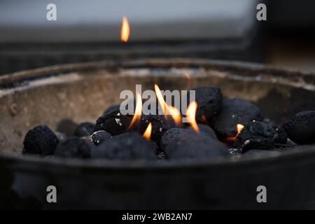 Charbon fumant dans le gril. Charbons brûlants pour barbecue lors d'un pique-nique Banque D'Images