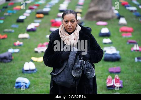 Yemi Hughes, tenant les vêtements que portait son fils André Aderemi, 19 ans, lorsqu'il a été poignardé à mort à Croydon en 2016, lors du lancement de la campagne Don't Stop Your future d'Idris Elba sur Parliament Square, Westminster, au centre de Londres, appelant à l'interdiction immédiate des machettes et des soi-disant couteaux zombies. La star de Luther fait également pression pour plus de financement dans les services à la jeunesse et publie une chanson dans un effort pour lutter contre la violence grave des jeunes à travers le Royaume-Uni. Date de la photo : lundi 8 janvier 2024. Banque D'Images