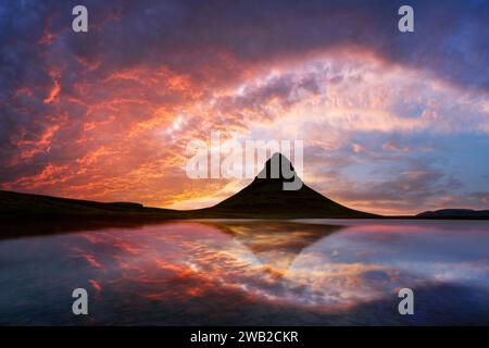 Coucher de soleil incroyable sur la montagne Kirkjufell reflété dans les eaux claires d'un lac de montagne en Islande. Photographie de paysage Banque D'Images