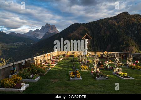 Cimetière de l'église au coucher du soleil entouré de montagnes Banque D'Images