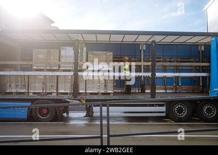 Récepteur d'entrepôt debout à l'intérieur du camion dans la zone de cargaison, remorque. Réceptionniste tenant la tablette, regardant les détails de la cargaison, vérifiant les articles livrés Banque D'Images