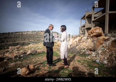 08 janvier 2024, Territoires palestiniens, Al-Mazraah Al Qibliyah : Annalena Baerbock (Bündnis90/Die Grünen), ministre des Affaires étrangères, s'entretient avec un résident de la communauté d'Al-Mazraah Al Qibliyah en Cisjordanie qui a été déplacé par la violence des colons, alors que la colonie israélienne de Haresha se trouve sur la colline derrière elle. Au cours de son voyage au Moyen-Orient, Baerbock a des entretiens en Israël, dans les territoires palestiniens, en Égypte et au Liban. Photo : Michael Kappeler/dpa Banque D'Images