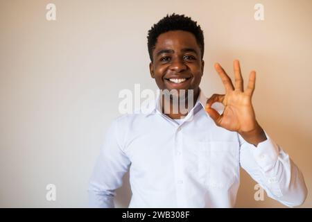 Portrait d'homme heureux qui sourit et montre un excellent signe. Copiez l'espace sur l'image pour votre texte ou publicité. Banque D'Images