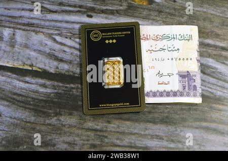 Le Caire, Egypte, janvier 6 2023 : 24k karats BTC Bullion Trading Center or jaune pur de 5 grammes de barre, et une pile de billet de banque d'argent égyptien 200 EGP LE Banque D'Images