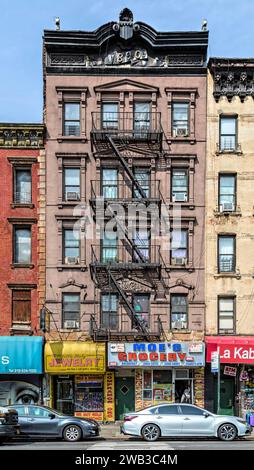 Une corniche en métal estampé surplombe le 1968 Third Avenue, un immeuble de cinq étages en briques et en grès brun avec des magasins construit en 1890. Banque D'Images