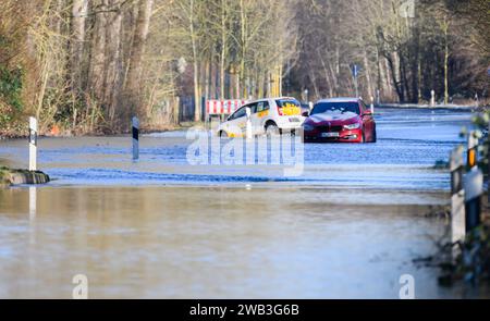 Hemmingen, Allemagne. 08 janvier 2024. Deux voitures sont garées sur une route entre Hanovre et Hemmingen dans la région de Hanovre qui a été inondée par la rivière Leine, qui a éclaté sur ses rives. Crédit : Sarah Knorr/dpa/Alamy Live News Banque D'Images