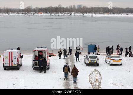 Non exclusif : KIEV, UKRAINE - 6 JANVIER 2024 - une ambulance et des voitures des services d'urgence, de la police et de la garde municipale sont garées sur l'eau Banque D'Images